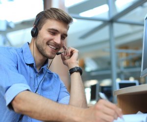 Smiling friendly handsome young male call centre operator.