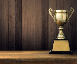 Trophies placed on a wooden floor with a space.