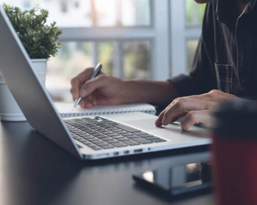 Business man working on laptop computer or student learning online at home office